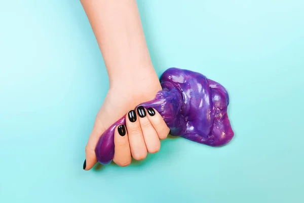 Händer med att hålla slem i lila färg — Stockfoto