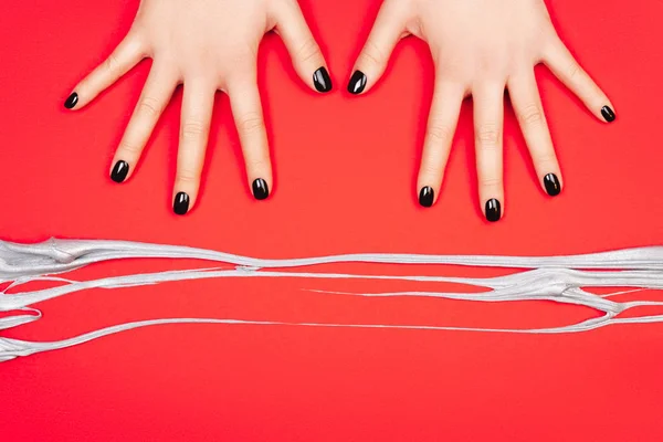 Black manicure on creative red background — Stock Photo, Image