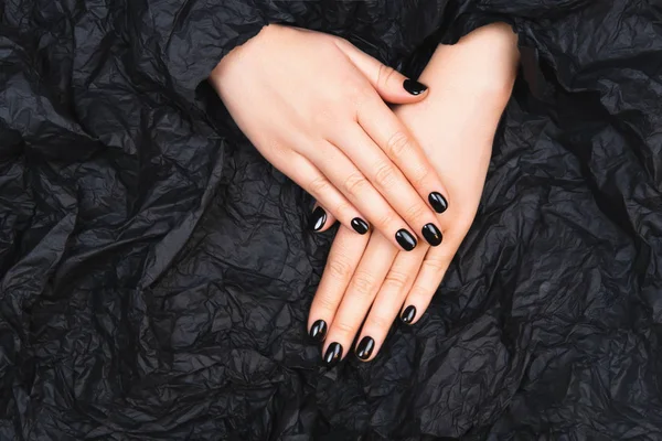 Zwarte manicure met verfrommeld papier — Stockfoto
