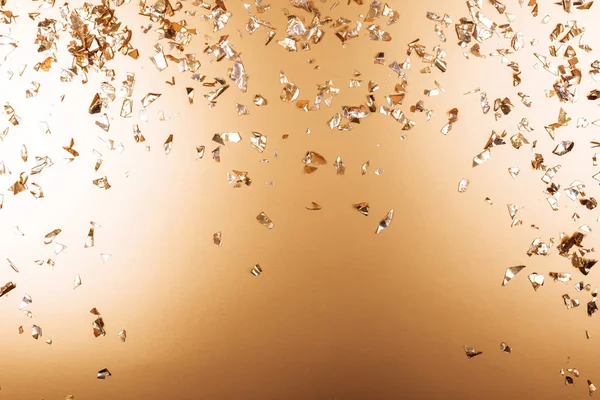 Golden falling confetti on metallic backdrop — Stock Photo, Image