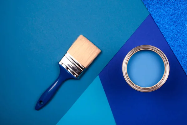 Penseel op open blik blauwe verf op blauwe ondergrond. — Stockfoto