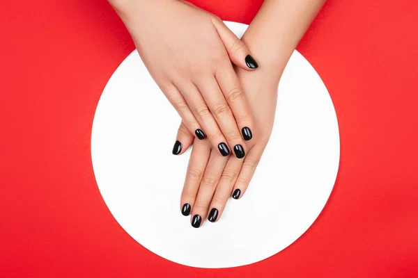 Black manicure on creative red background