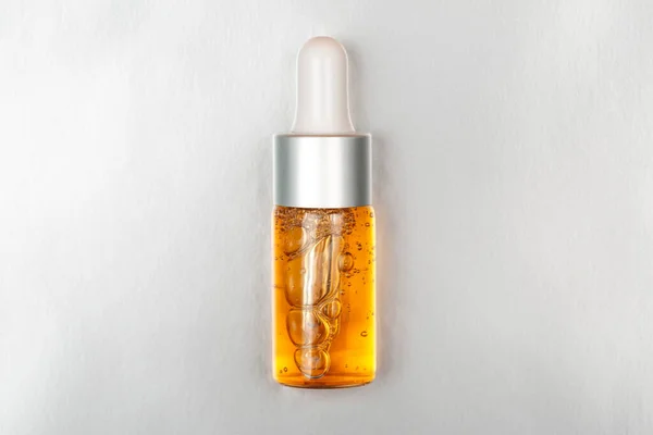 Bottle of beauty oil on silver luxury background — Stock Photo, Image