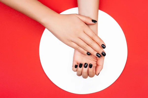 Black manicure on creative red background