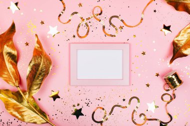 Pembe arkaplan üzerine altın madalyalı not defteri.