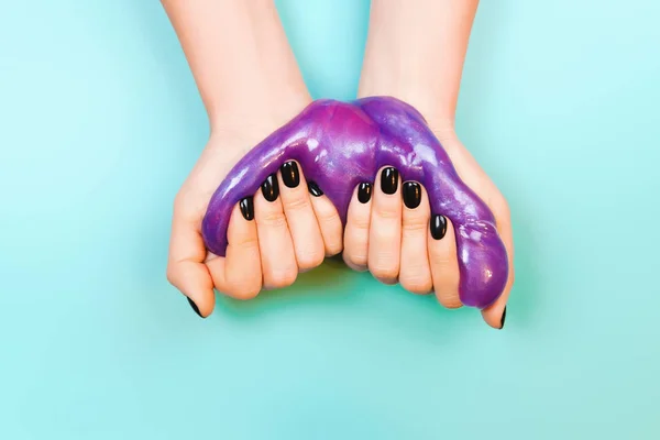 Руки с держа слизь фиолетового цвета — стоковое фото