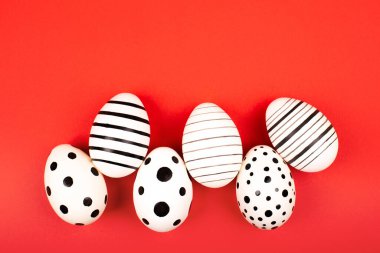 Parlak kırmızı arka planda farklı grafik el boyalı yumurta. Paskalya konsepti. Düz yatlı stil.