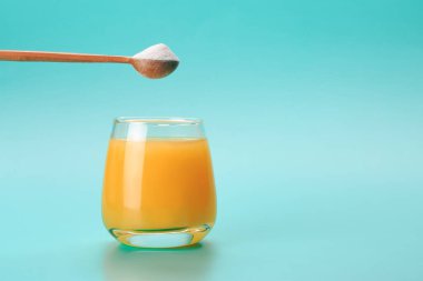 Bir kaşık protein ya da kolajenle portakal suyu. Gıda takviyesi konsepti