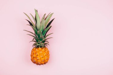 Pembe arka planda sarı ananas. Düzleştirme biçimi