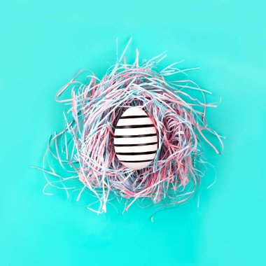 Mavi Pastel arka planda dekoratif yuvada çizgi yumurta el boyalı grafik. Paskalya konsepti.