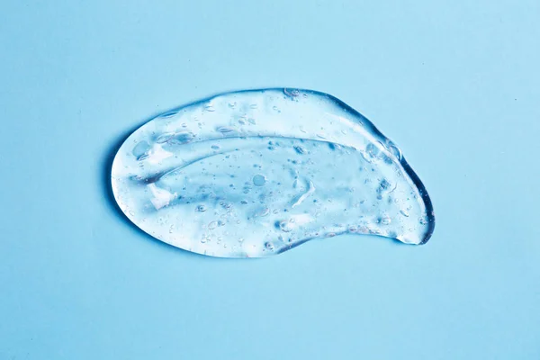 Frottis de gel transparent sur fond bleu . — Photo