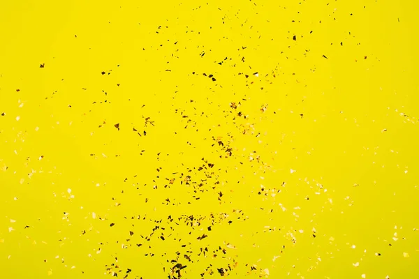 Scintille volanti dorate su sfondo giallo brillante . — Foto Stock