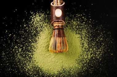 Chasen, özel bambu kibrit çay çırpısı siyah yüzeyde pudralanmış kibrit üzerinde yatıyor..