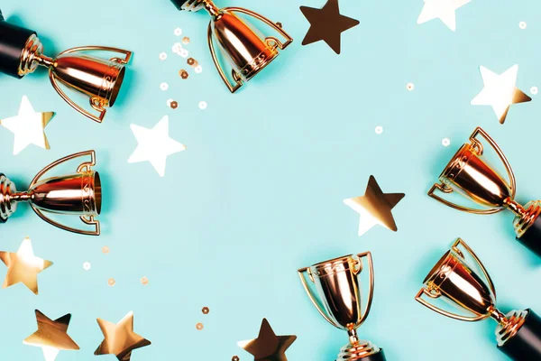 Gouden Bekers Van Winnaar Met Glanzende Confetti Een Blauwe Achtergrond — Stockfoto