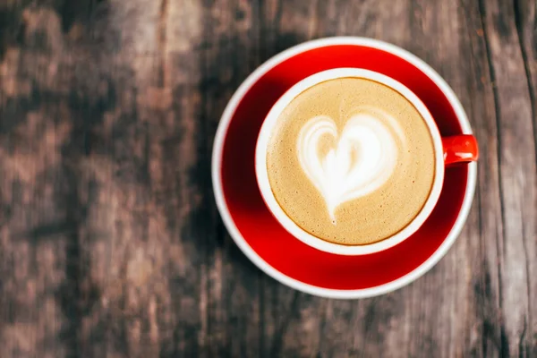 Eski Ahşap Arka Planda Güzel Latte Sanatıyla Kırmızı Kapuçino Bardağı — Stok fotoğraf