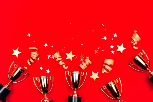 Three Golden Winner Cups Confetti Red Background Flat Lay Style — Stock Photo, Image