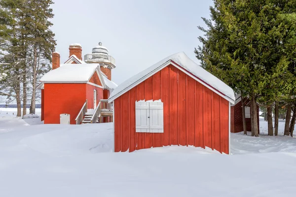 Červené Budovy Bílými Okenicemi Zasazenými Hlubokého Sněhu Rámované Zelenými Borovicemi — Stock fotografie