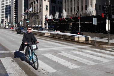 Chicago, ABD - 30 Aralık 2018: Michigan Bulvarı 'nda mavi Divvy marka kiralık bir bisiklete binen adam. Motosiklet paylaşımı, 6000 'den fazla motosiklet ve 600' den fazla mekanla Chicago 'da popüler bir seçenek.