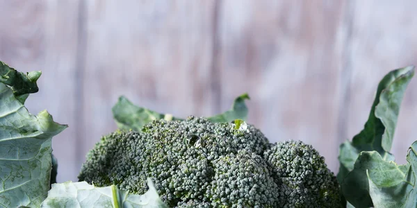 Ahşap arka plan üzerinde çiğ brokoli. Başlık resmi — Stok fotoğraf