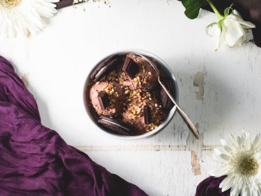 Çikolatalı dondurma kaşık toz kase beyaz masada