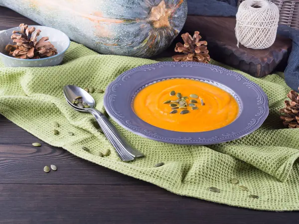 Soupe à la crème de citrouille dans une assiette sombre. Déjeuner d'automne — Photo