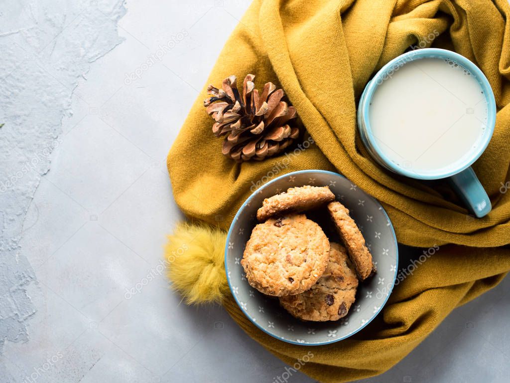 Mug of tea with milk and cookies in soft scarf