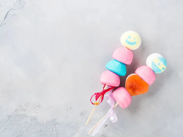 Bolo de marshmallows colorido aparece rosto masculino e feminino — Fotografia de Stock