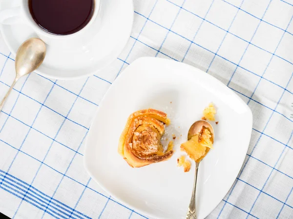 Broodje roll op geruite tabel doek met thee — Stockfoto