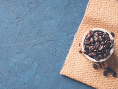 Çuval bezi üzerinde espresso fincan kahve çekirdekleri
