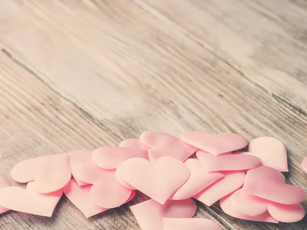 Roze hartjes op getextureerde houten tafel. Getinte Valentine — Stockfoto