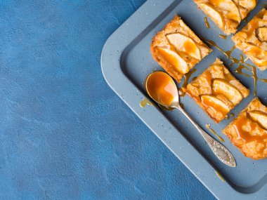 Apple sarışın kek tepsi mavi zemin üzerine karamel ile