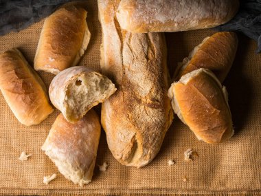 Çuval bezi koyu ahşap arka plan üzerinde taze pişmiş ekmek