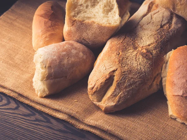 Versgebakken brood op jute donkere houten achtergrond — Stockfoto