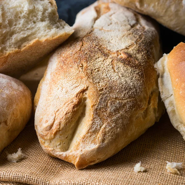 Frisch gebackenes Brot auf dunklem Holzhintergrund — Stockfoto
