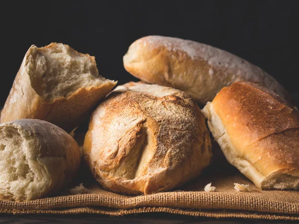 Versgebakken brood op jute donkere houten achtergrond — Stockfoto