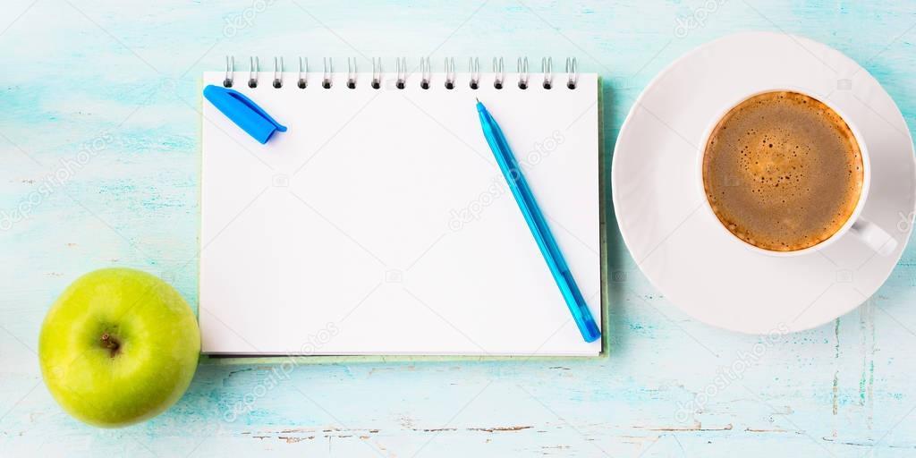 Blank notebook page with blue pen and cup coffee flowers