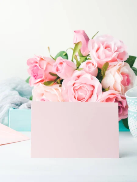 Tarjeta rosa de papel en blanco el día de San Valentín y rosas invitación — Foto de Stock