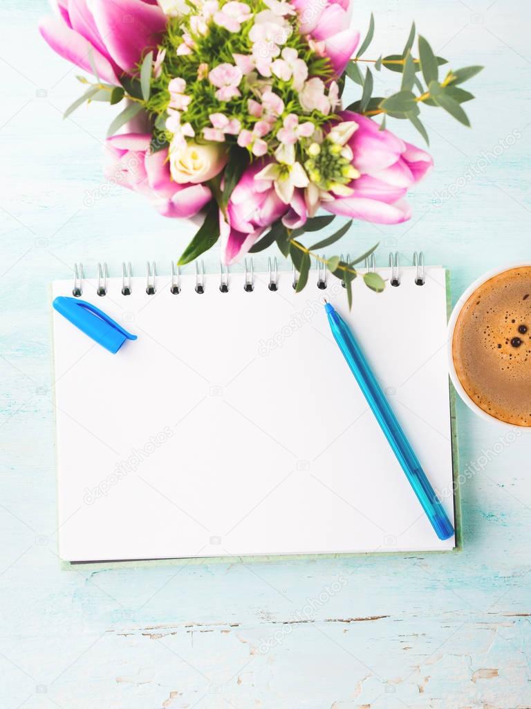 Blank notebook page with blue pen and cup coffee flowers