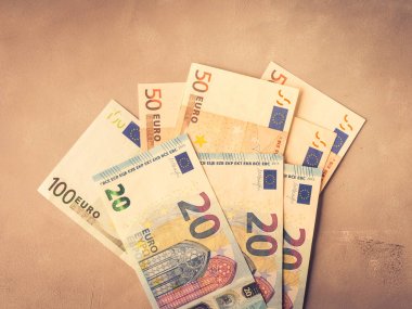 Euro money banknotes on textured backdrop. Top view toned clipart