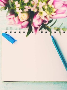 Mavi Kalem ve çiçekler ile boş defter beyaz sayfa