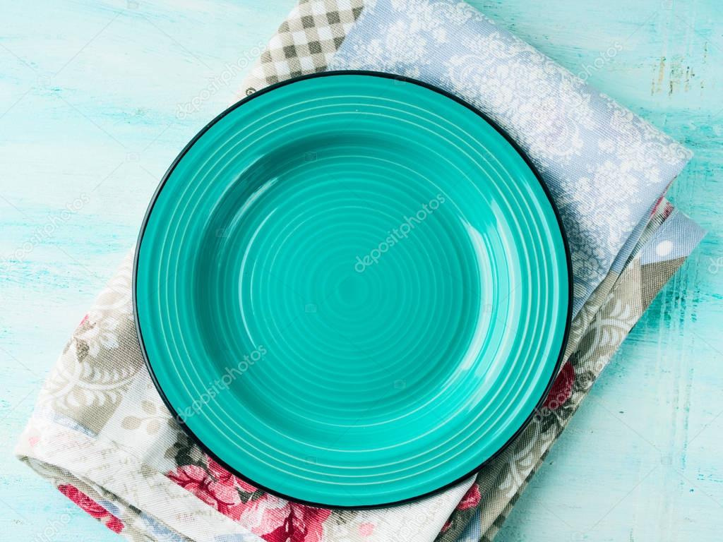 Green plate on Vintage napkin wooden textured background