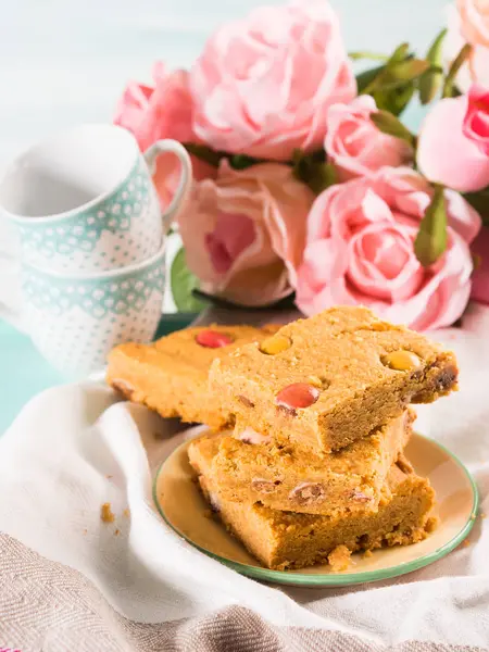 Festive breakfast flowers peanut butter bownies on pastel — Stock Photo, Image