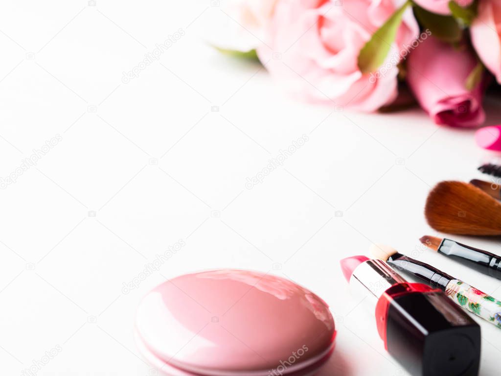 Make up products and tools with pink roses flowers on white