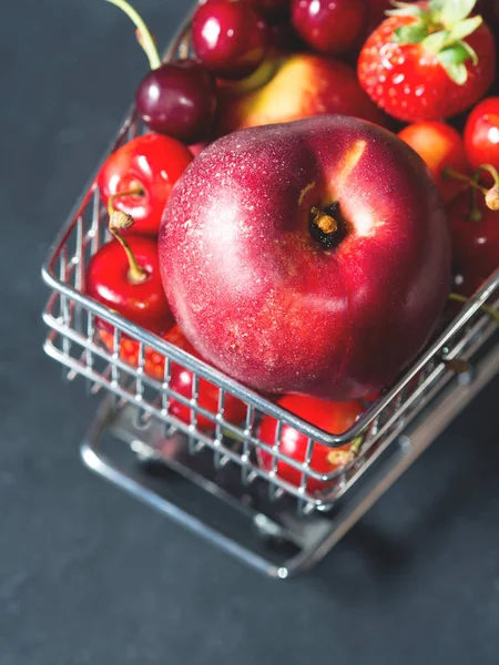 Fresh red fruit berries supermarket cart on black — Stock Photo, Image