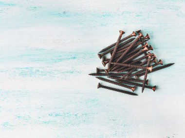 Yeşil ahşap arka plan üzerinde bronz vidalar