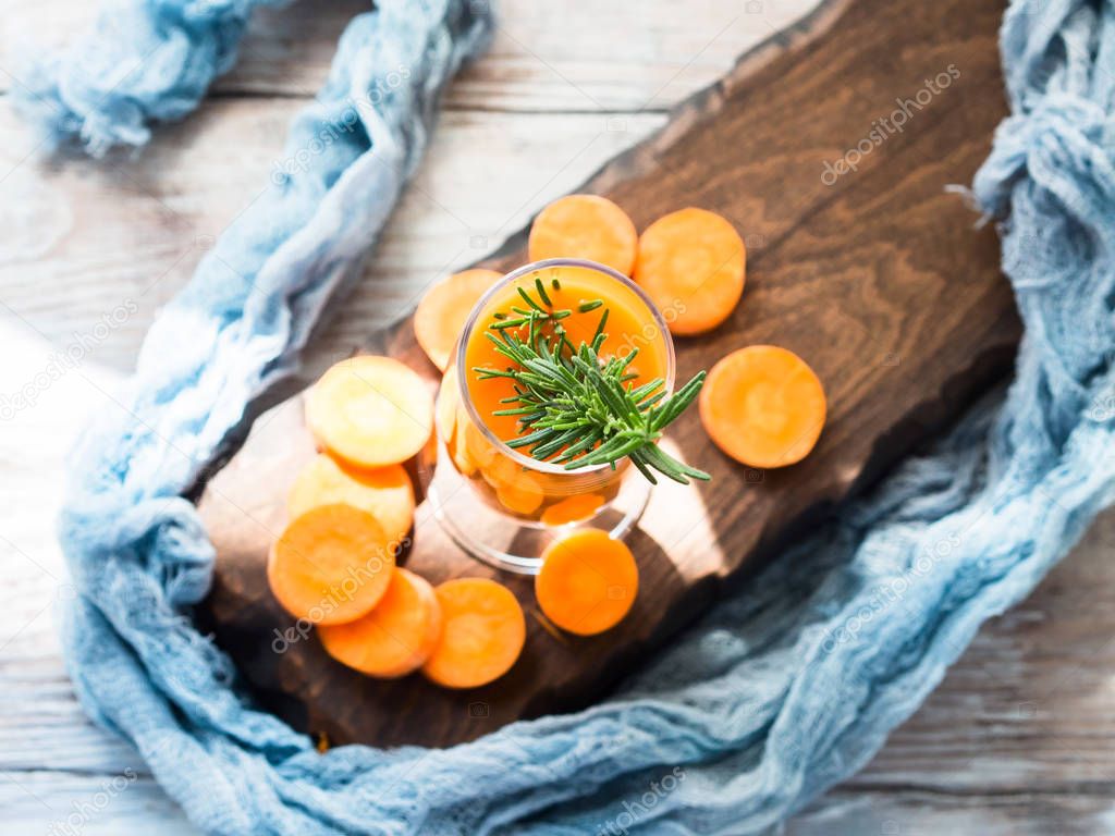 Orange carrot juice on wooden board