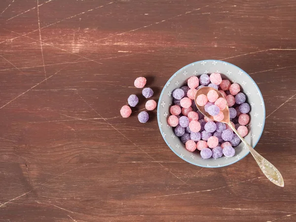 Bol à bonbons violet et rose sur fond en bois — Photo