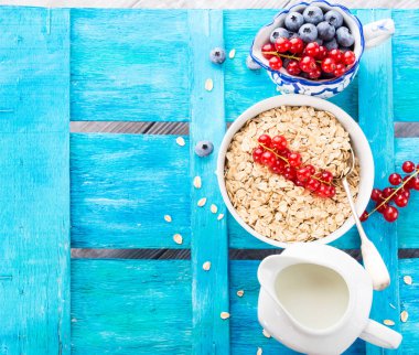 Yulaf ve çilek mavi dokulu arka plan üzerinde haddelenmiş