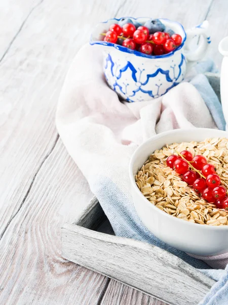 Rohe Haferflocken mit frischen Beeren auf Holztisch — Stockfoto