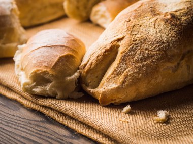 Çuval bezi koyu ahşap arka plan üzerinde taze pişmiş ekmek